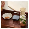 A tray with a coffee set, a cookie, and a small electronic device. Anteprima dell’immagine prodotto