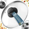 A close-up view of a glass pot lid with a black handle, showing a size guide attached to the handle. The background is white with some blurred food items on the sides. Anteprima dell’immagine prodotto