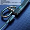 Close-up of a Bluetooth earphone with a USB-C cable plugged in, against a textured blue background. Náhľad obrázku produktu