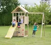 Children playing on a wooden playground set in a grassy backyard. Podgląd zdjęcia produktu