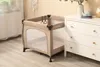 A baby playpen is shown next to a white dresser in a room. Produktbild-Vorschau