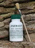 A bottle of KERALIT Huf-Festiger and a brush are placed on a textured wooden surface. Produktbild-Vorschau