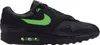 A side view of a black Nike Air Max 1 Essential sneaker with green accents. Produktbild-Vorschau