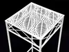 A white metal plant stand with a decorative patterned top, shown against a black background. Anteprima dell’immagine prodotto