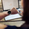 A person wearing a smartwatch is looking at their laptop. Produktbild-Vorschau