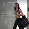 A woman is holding a black bag with a pink flamingo logo, standing in front of a gray and white background. Text lists benefits of infrared sauna. Produktbild-Vorschau