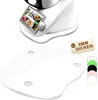 A white acrylic mat for a kitchen appliance is shown in the foreground, with the appliance itself visible in the background. Several colored rings are also displayed. Produktbild-Vorschau