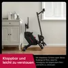 A rowing machine is shown in a room next to a cabinet and a window. Produktbild-Vorschau