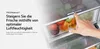 A hand is adjusting a dial on a refrigerator drawer filled with fruits. Produktbild-Vorschau