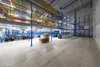 A large, modern warehouse interior with multi-level shelving and storage systems. Produktbild-Vorschau
