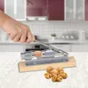 A hand is using a nutcracker to crack a walnut on a kitchen counter. Voir les images du produit