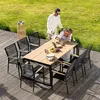 A couple enjoying a meal at a wooden outdoor dining table on a deck, with a grassy lawn in the background. Náhled obrázku produktu