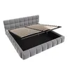 A grey upholstered bed frame with its storage mechanism open, revealing the slatted base and storage compartment. Voir les images du produit