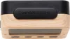 Close-up view of the top and side of a small electronic device, likely an alarm clock, showing wood grain and a black button with text. Produktbild-Vorschau