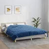 A bedroom scene with a bed covered by a blue blanket. Produktbild-Vorschau