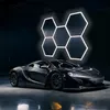 A black sports car is parked in a dark garage with hexagonal LED lights on the wall. Náhled obrázku produktu