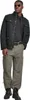 A man wearing a black jacket and gray cargo pants, posing against a white background. Produktbild-Vorschau