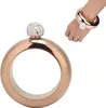 A rose gold flask bracelet with a crystal-covered cap, shown on a white background and on a person's wrist. Podgląd zdjęcia produktu