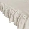 A close-up view of a light gray bed skirt with ruffles. Podgląd zdjęcia produktu