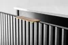 A close-up of a black ribbed cabinet with a gold handle and a white countertop. Anteprima dell’immagine prodotto