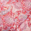 A close-up view of a red fabric with a paisley pattern. Produktbild-Vorschau