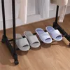 A close-up shot of four pairs of open-toed slippers arranged on a black rack. Anteprima dell’immagine prodotto