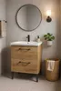 A bathroom vanity with a sink, faucet, mirror, and a basket. Voir les images du produit