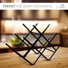 A black metal wine rack is displayed on a wooden table in a blurred kitchen background. Produktbild-Vorschau