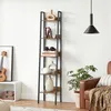 A tall, narrow bookshelf with five shelves is displayed against a white wall. Decorative items and books are placed on the shelves. A brown leather armchair and a potted plant are visible to the right. Podgląd zdjęcia produktu