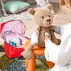 A child playing doctor with a teddy bear, using a toy doctor's kit. Anteprima dell’immagine prodotto
