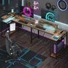A gaming setup with an L-shaped desk, multiple monitors, a gaming chair, and a computer tower, all illuminated by LED lighting. Anteprima dell’immagine prodotto