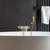 A close-up shot of a modern gold bathtub faucet with water flowing into a white bathtub. Náhled obrázku produktu