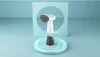 A white handheld garment steamer is displayed on a light blue circular platform against a light blue background. Voir les images du produit