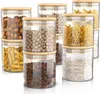 A set of glass storage jars with bamboo lids filled with various food items like nuts, pasta, and grains, arranged on a white background. Náhled obrázku produktu