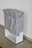 A gray blanket is draped over a white shelf unit. Produktbild-Vorschau