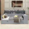 A grey daybed with a built-in bookshelf and desk, styled with pillows and blankets. Produktbild-Vorschau