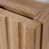 Close-up view of the corner of a wooden cabinet with a fluted or ribbed door. Anteprima dell’immagine prodotto