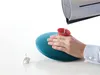 A person is filling a hot water bottle with hot water from a kettle. Produktbild-Vorschau