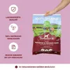 A hand holding a bag of dog food with marketing text and icons on the side. Produktbild-Vorschau