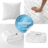 A collage of images showing a white quilted pillow, a hand pressing on a white quilted surface, and folded white quilted blankets. Produktbild-Vorschau