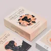 A close-up shot of tarot card boxes and cards on a light gray background. Voir les images du produit