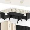 A black polyrattan corner lounge set with cream cushions and a black table, displayed on a white background.