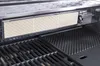 Close-up view of a grill's internal components, focusing on a ceramic heat diffuser and grill grates. Produktbild-Vorschau