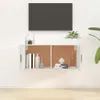 A white wall-mounted TV cabinet with two doors, open to reveal shelves with books and decorative items. A TV is mounted on the wall above the cabinet. Voir les images du produit