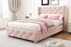 A pink upholstered bed with a tufted headboard and footboard, set in a bedroom with curtains and a rug. Produktbild-Vorschau
