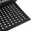 A close-up, angled view of a black rubber mat with a honeycomb pattern of holes. Podgląd zdjęcia produktu
