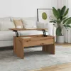 A lift-top coffee table is shown in a living room setting, with a sofa and a plant in the background. Produktbild-Vorschau