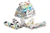 A stack of rolled-up baby cloths with various animal and pattern prints, with a few cloths laid out in front. Produktbild-Vorschau