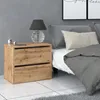 A bedside table with a lamp next to a bed. Produktbild-Vorschau