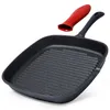 A black cast iron grill pan with a red silicone handle cover is shown against a white background. Anteprima dell’immagine prodotto